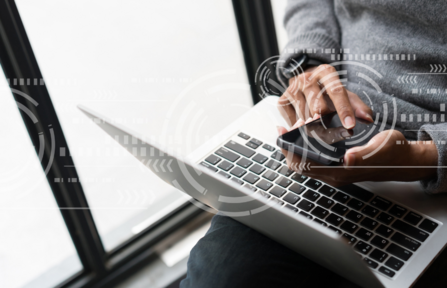 Person checks phone message and laptop